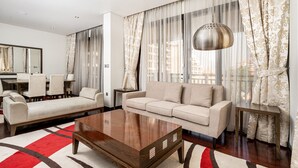 A modern living room with a sofa, coffee table, and dining area.