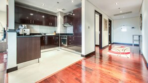 A modern kitchen with dark wood cabinets, stainless steel appliances, and a central island.