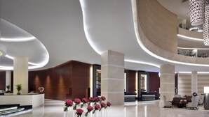 A modern lobby with a curved ceiling, a reception desk, and a seating area. - Graceful 1BR at The Address Residences Dubai Marina by Deluxe Holiday Homes (Dubai)
