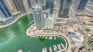 A high-rise building with a marina and construction cranes in the background. - Graceful 1BR at The Address Residences Dubai Marina by Deluxe Holiday Homes (Dubai)