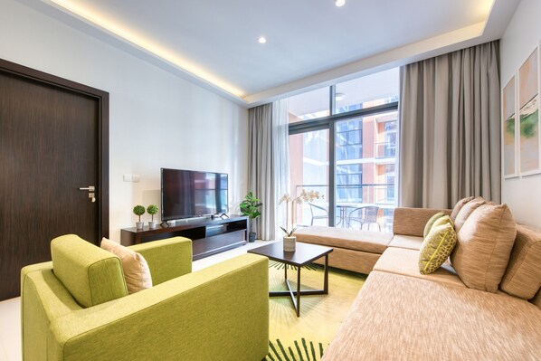 A modern living room with a sofa, a television, and a coffee table.