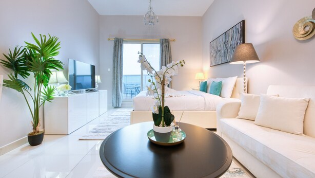 Een moderne hotelkamer met een groot bed, een bank, een bijzettafeltje en een televisie.