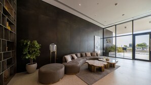 A modern living room with a sectional sofa, a coffee table, and a bookshelf.