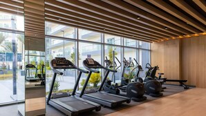 A modern gym with treadmills, stationary bikes, and ellipticals.