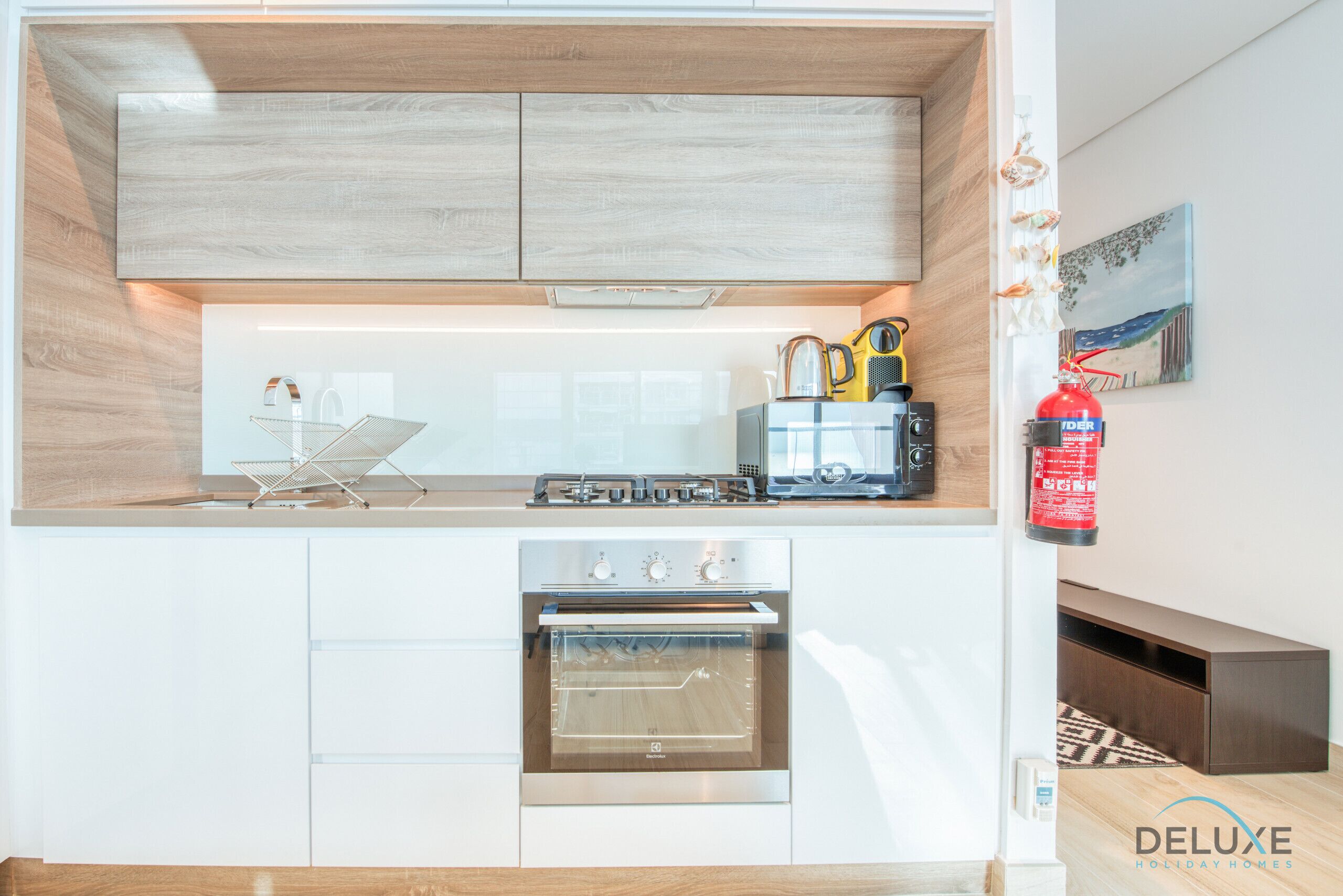 A modern kitchen with a built-in oven, a coffee maker, and a toaster on the countertop.