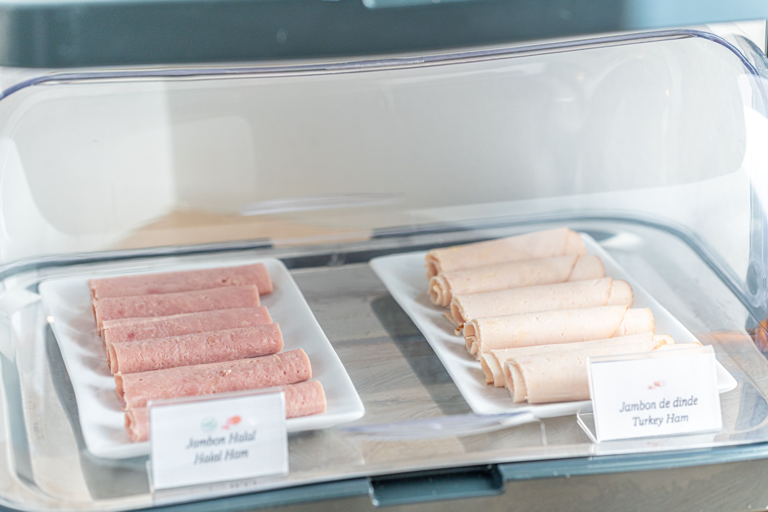 Eine Kühlvitrine mit Lebensmitteln, darunter Putenbrust und Schinken-Käse.