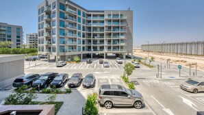 Um edifício moderno de vários andares com um estacionamento na frente.