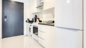 Eine moderne Küche mit Waschmaschine, Backofen und Kühlschrank.