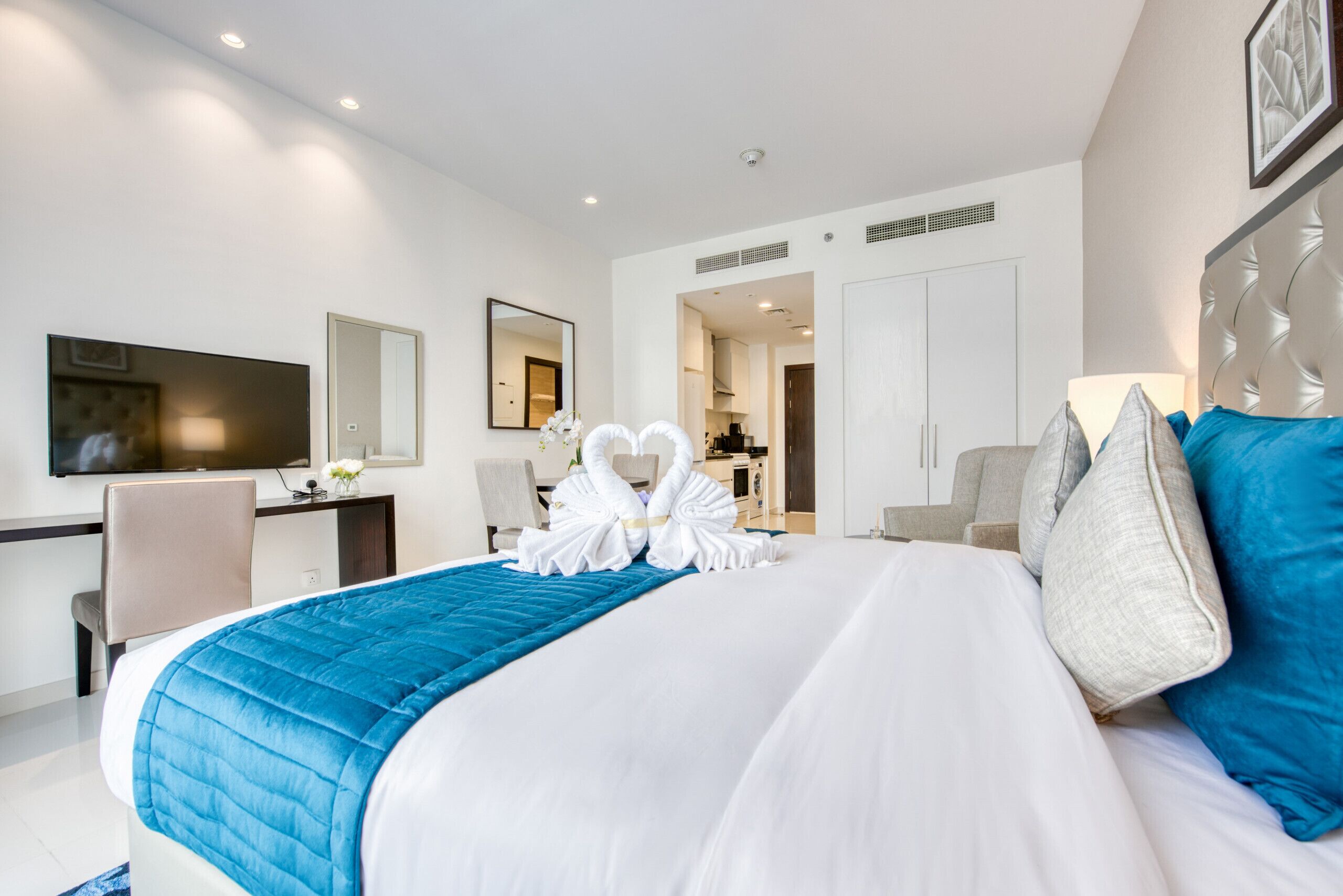 Une chambre d’hôtel avec un grand lit, un bureau, une télévision et un miroir.