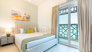 Ein modernes Schlafzimmer mit einem großen Bett, einem Nachttisch, einem Gemälde und Balkonblick.