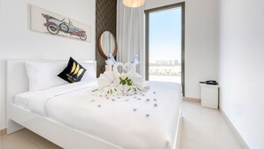 Ein Hotelzimmer mit einem großen Bett, Blick auf die Stadt, einem Gemälde eines Oldtimers und einem dekorativen Spiegel.