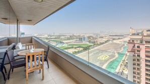 Uma varanda com vista para um horizonte urbano, incluindo edifícios e um campo esportivo.