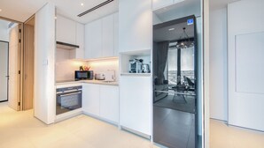 Eine moderne Küche mit weißen Schränken, einem eingebauten Backofen und einem Essbereich mit Blick.