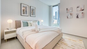 Ein modernes Schlafzimmer mit einem großen Bett, zwei Nachttischen und einem Blick auf die Stadt.