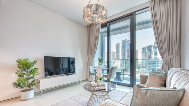 Ein modernes Wohnzimmer mit Fernseher, rundem Couchtisch und einer Couch.