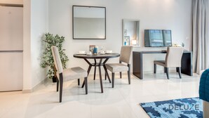 Ett modernt hotellrum med en matplats, ett skrivbord och en stor spegel.