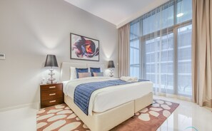 A modern hotel room with a large bed, two bedside tables, a painting on the wall, and a view through the window.