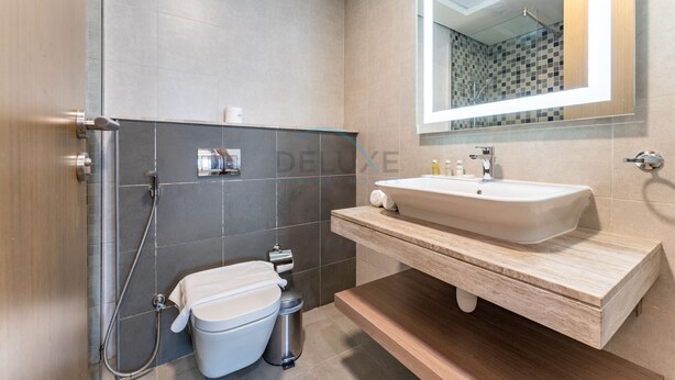 A modern bathroom with a shower, toilet, and sink.