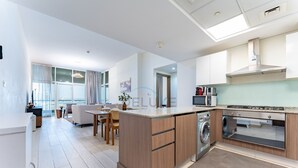 A modern kitchen with a built-in dishwasher, a microwave, and a stainless steel range hood. - Huge Balcony Overlooking Creek Harbour with Glimpses of Burj Khalifa (Dubai)