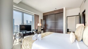 Una habitación de hotel con una cama grande, televisión, escritorio y vista a la ciudad.