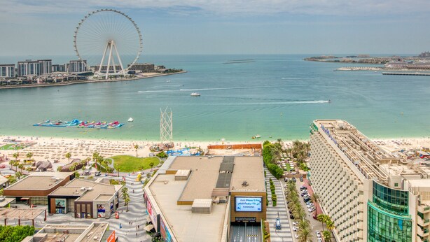 A coastal cityscape with a prominent Ferris wheel, beachfront hotels, and a clear view of the sea. - Elegant 2BR at Bahar 2 JBR by Deluxe Holiday Homes (Dubai)