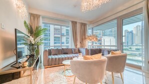 Un salon moderne comprenant un canapé, deux fauteuils, une table basse et un téléviseur.