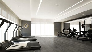 A modern gym with treadmills, weight machines, and a large window providing natural light. - Radiant Studio at Giovanni Boutique Suites DSC by Deluxe Holiday Homes (Dubai)