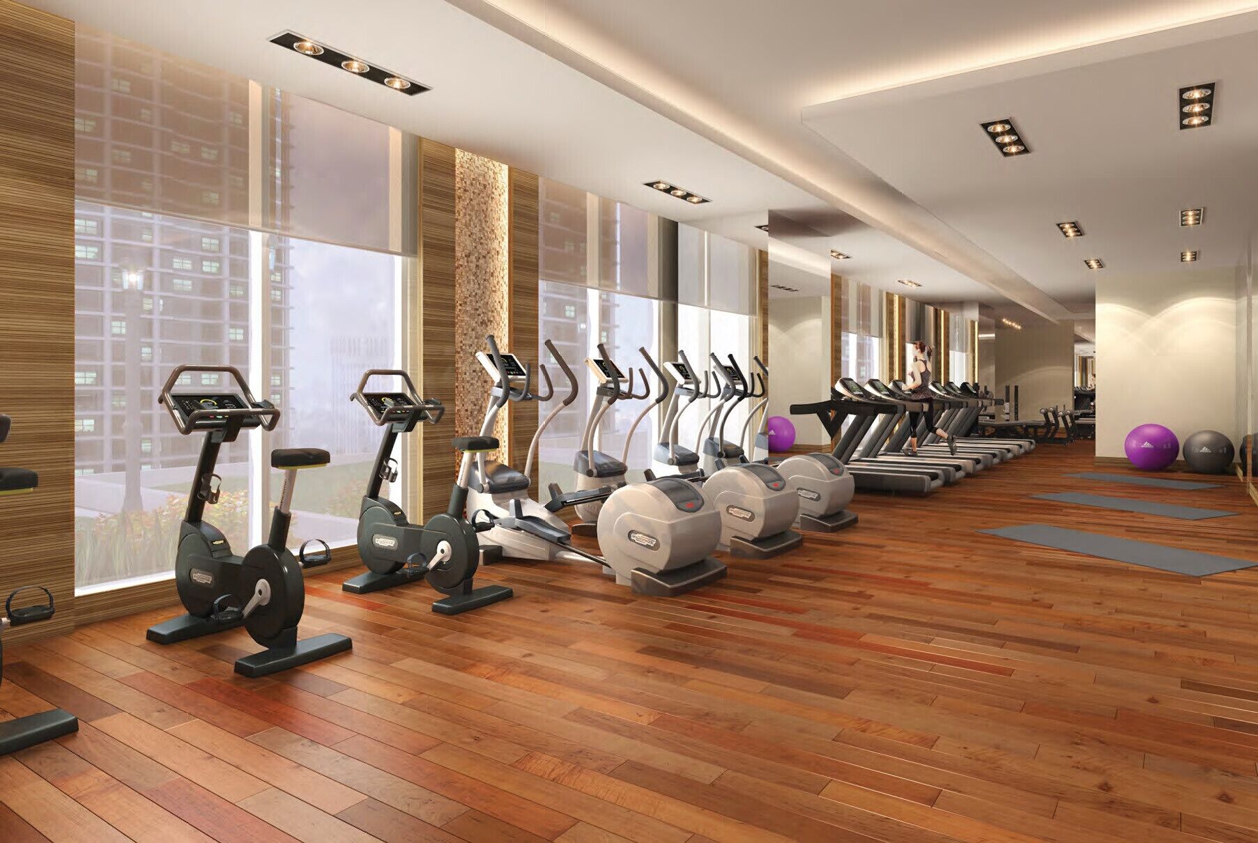 Une salle de sport équipée de plusieurs tapis de course, de vélos d’appartement et de ballons d’exercice.