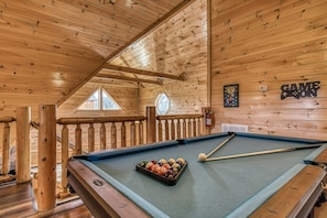 Enjoy games and relaxation in this room featuring a pool table and balcony access.