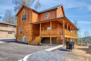 A wooden log cabin with a balcony, a staircase leading to the upper level, and a sign indicating it is a fire lodge.