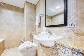 Un baño con un lavamanos blanco, un espejo y un inodoro.