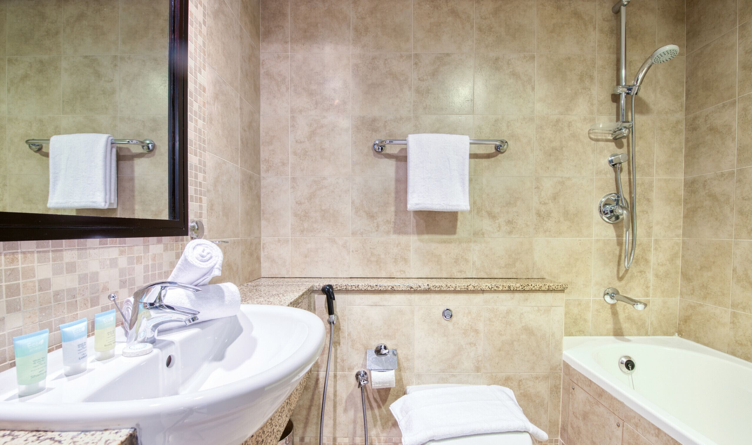 A bathroom with a sink, mirror, shower, and bathtub.