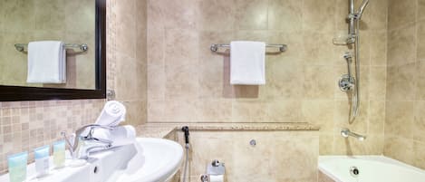 A bathroom with a sink, mirror, shower, and bathtub.