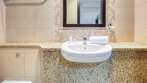 A bathroom with a granite countertop, a white sink, a mirror, and a towel rack. - Gorgeous 1BR at Sky Gardens DIFC by Deluxe Holiday Homes (Dubai)