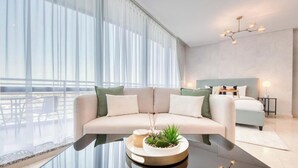 Ein modernes Hotelzimmer mit großem Fenster, einer Couch, einem Nachttisch, einem Bett und einer besonderen Kandelaber.