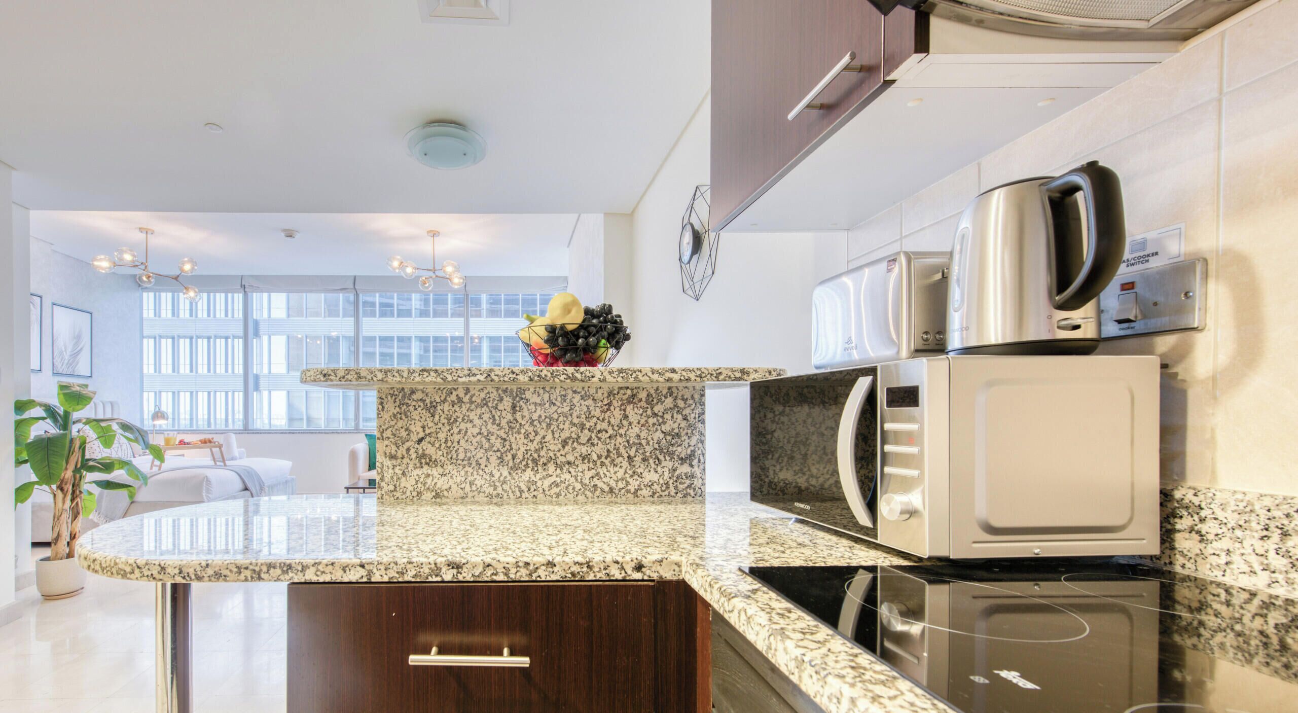 Una cocina moderna con encimeras de granito, electrodomésticos de acero inoxidable y vista al área de estar.