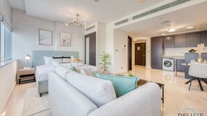 Ein modernes Hotelzimmer mit einem großen Bett, einer Couch, einem Schreibtisch und einer Küchenzeile.