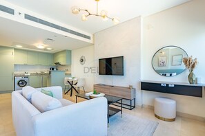 Una sala de estar moderna con un sofá, una mesa de centro y un televisor montado en la pared.