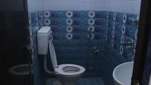 A small bathroom with a toilet, bidet, and sink. - SK Guest House  (Visakhapatnam)