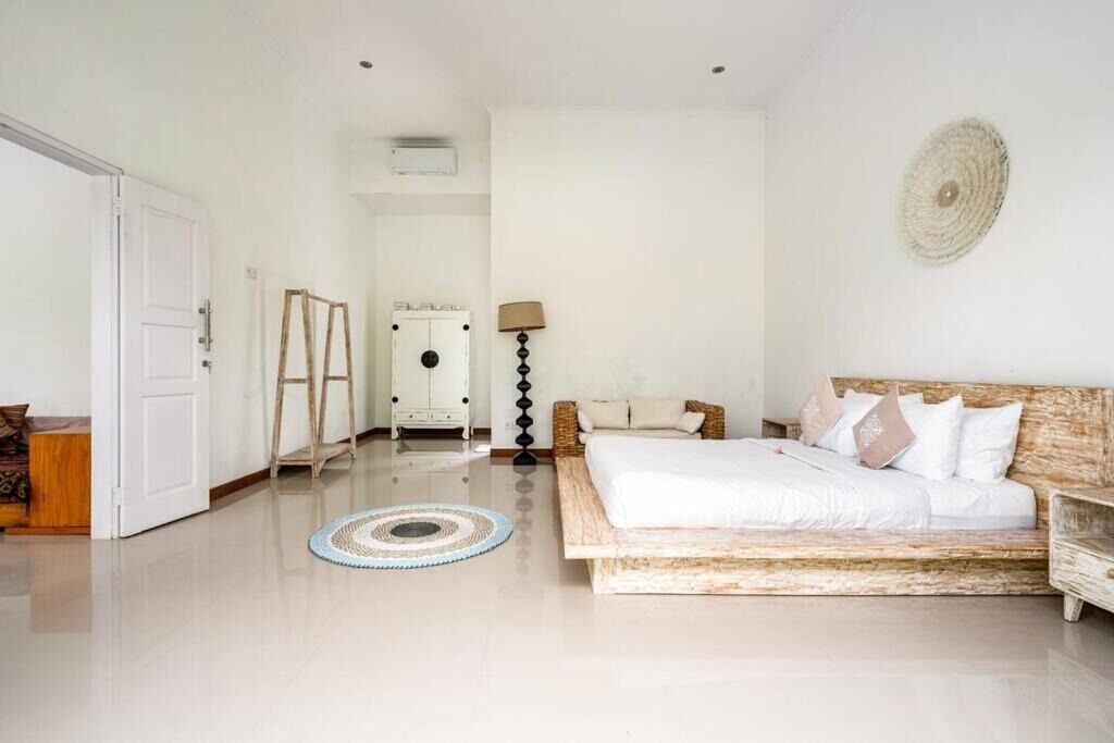 Un dormitorio con una cama grande, un armario, una mesita de noche, una lámpara y un adorno circular en la pared.