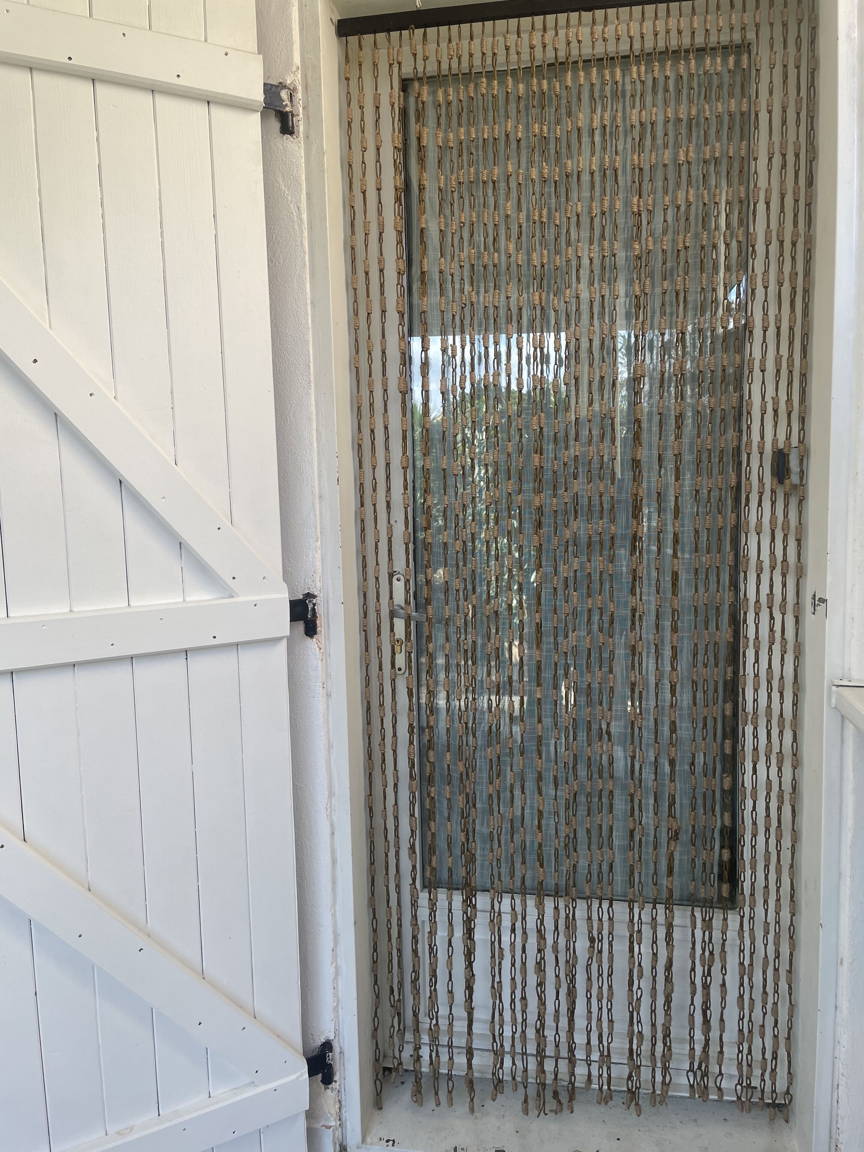 A white door with a chain-link security system.