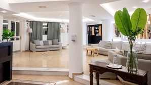 Un salon moderne avec un canapé, une table basse et un vase décoratif.