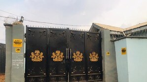 A gated property entrance with a metal gate featuring decorative golden motifs. - Umbrella Properties Eleyele Ibadan (Ibadan)
