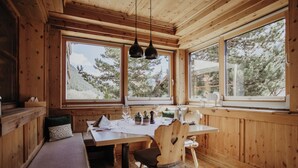 Un interior de madera con una mesa de comedor, sillas y un banco.