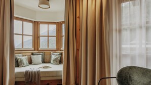 Una habitación acogedora con un banco incorporado, ventanas amplias y vistas a montañas.
