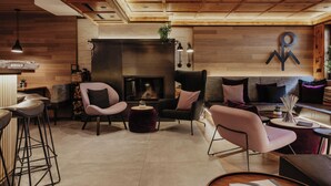 Una sala de estar moderna con chimenea, techo de madera y muebles contemporáneos.