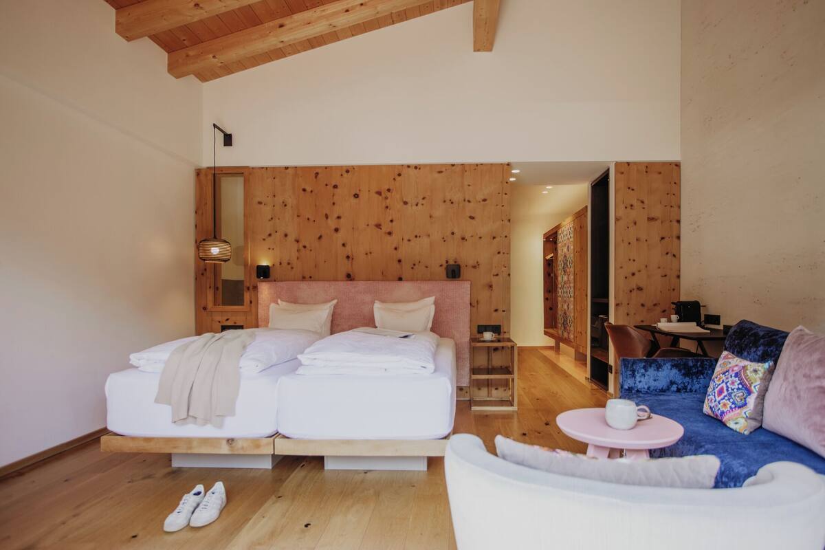 Un dormitorio con cama, sofá, una mesita y una silla.