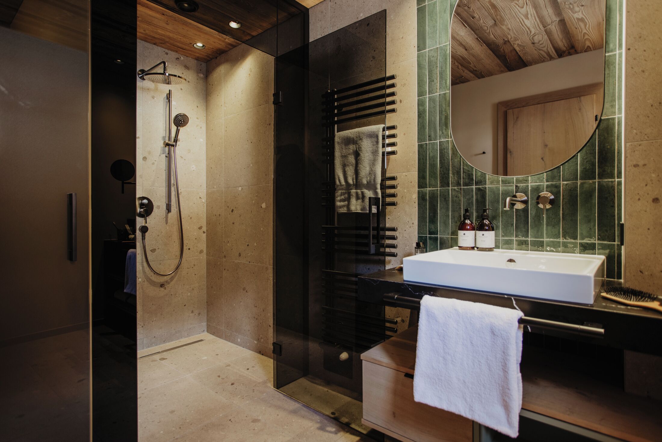 A modern bathroom with a glass-enclosed shower, a wooden vanity with a sink, and a mirror.
