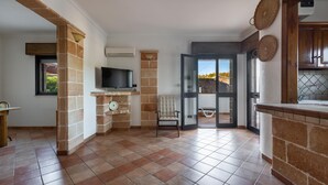 A spacious living area with a fireplace, a television, and a view of the outdoors.