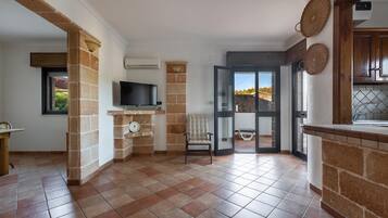 A spacious living area with a fireplace, a television, and a view of the outdoors.